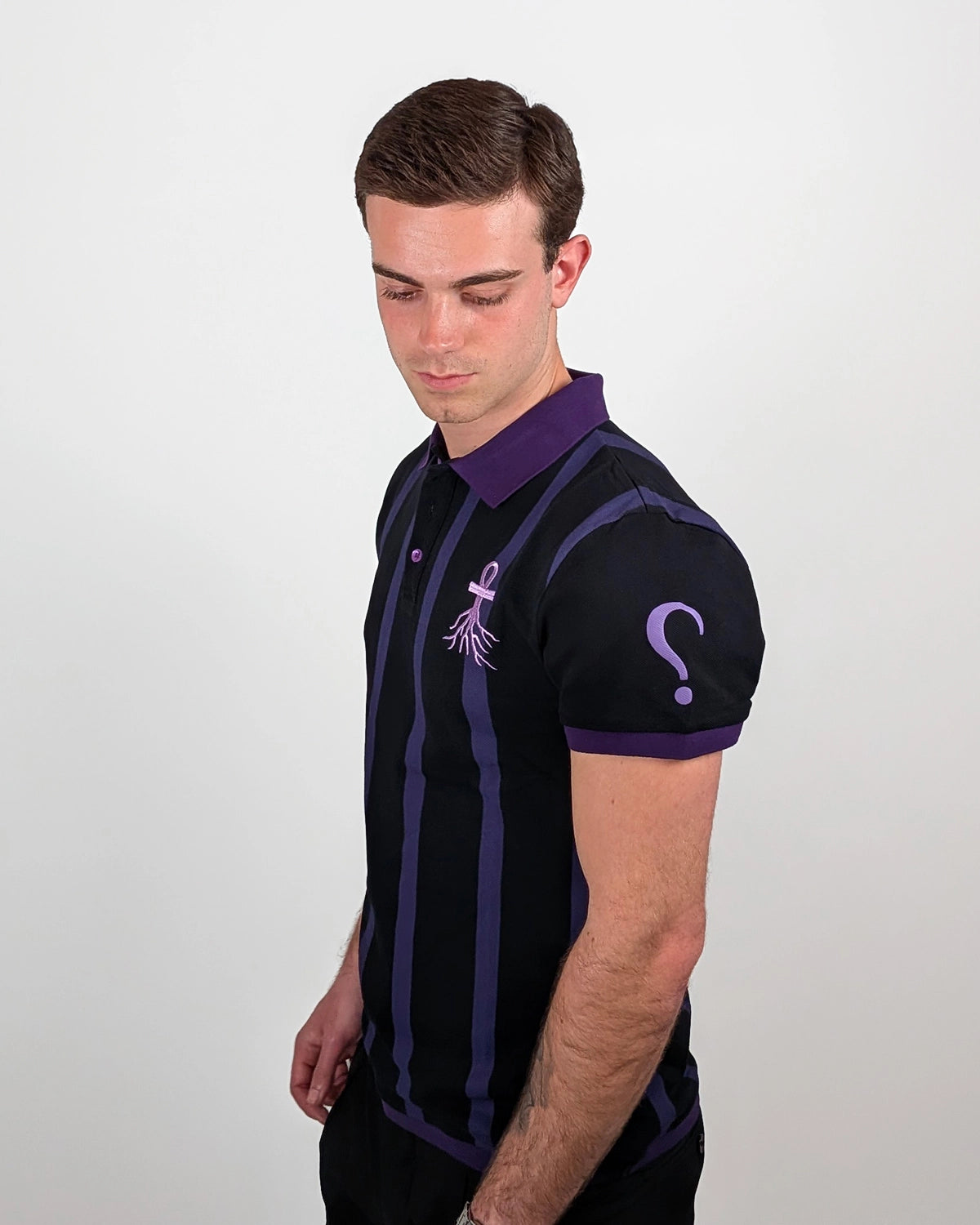 Side profile WESSENCE ENIGMA striped polo, purple collar and sleeve details, premium streetwear.