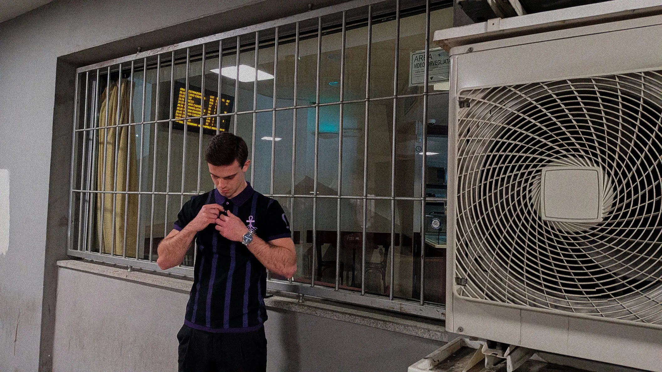 Model wearing WESSENCE ENIGMA striped polo in urban setting, streetwear collection preview.